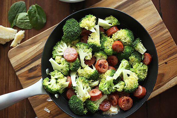 Adding broccoli to skillet.