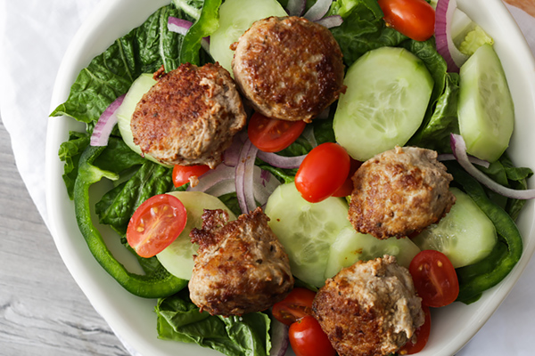 Salad with meatballs on top.