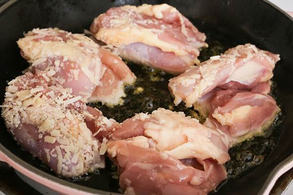 Cooking chicken thighs in sun-dried tomato oil.