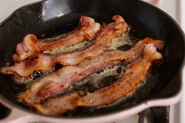 Bacon strips frying in the pan.