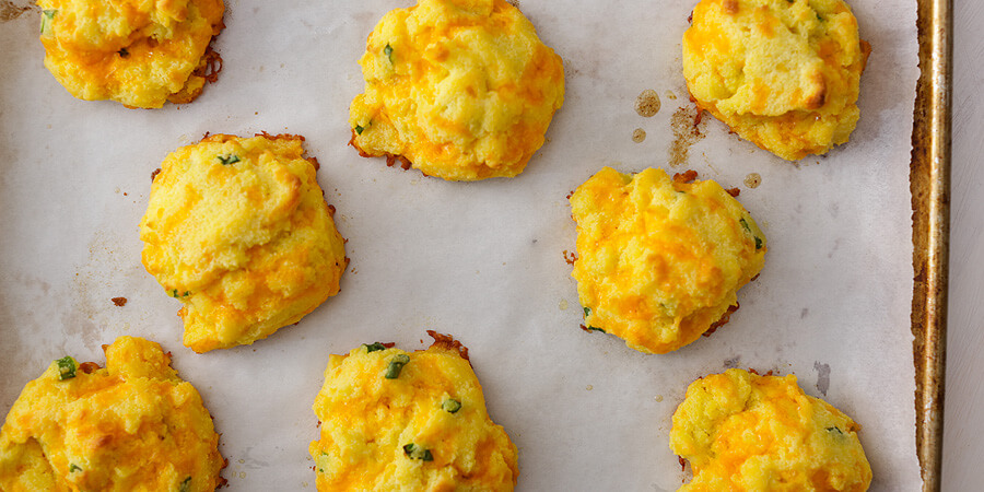 keto cheddar biscuits on a baking sheet.