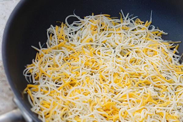 Melting cheese in a skillet.