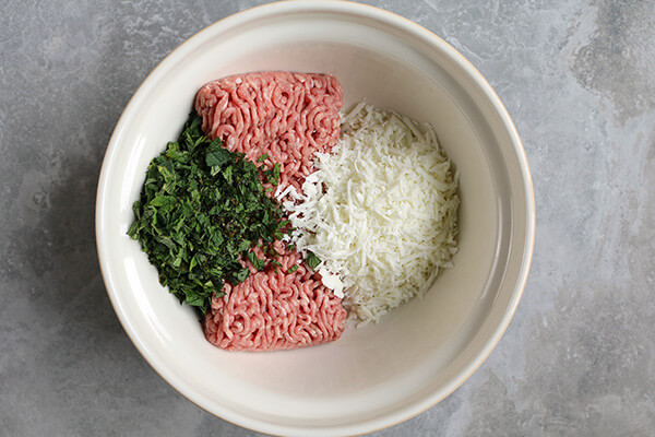 Grated cheese and other burger ingredients.