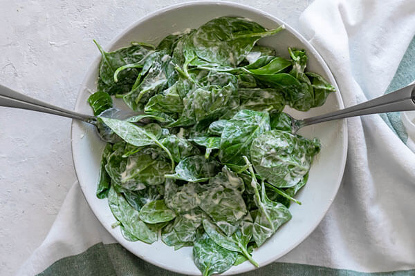 Spinach tossed with dressing.