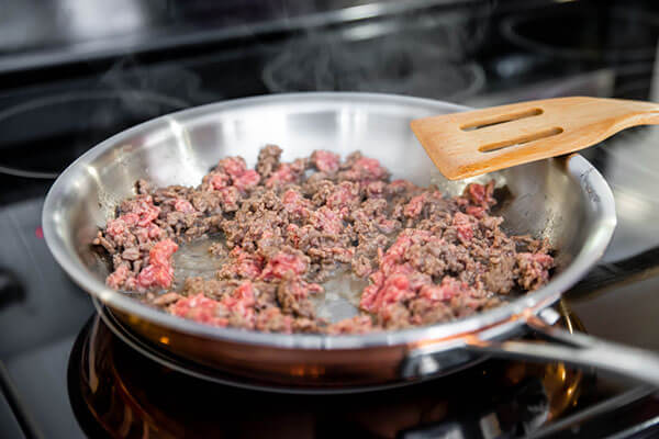 Cooking ground beef.